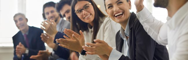 Group of people thanking speaker for interesting presentation in professional business conference or seminar. Team of happy male and female company workers applauding colleague in corporate meeting